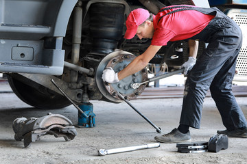 Fototapeta na wymiar A mechanic repairs a truck. Replace brake disc and pads