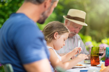  family lunching in the garden focus on a beautiful little girl