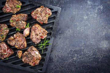 Barbecue T-bone lamb steak with seasonings as top view on a grillage © HLPhoto