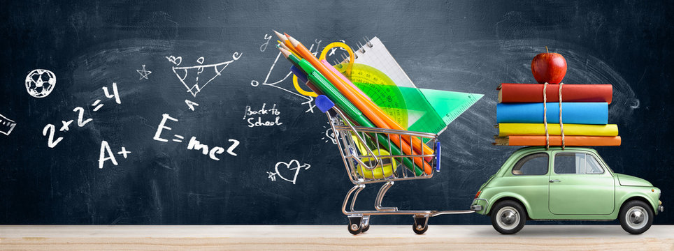 Back to school sale background. Car delivering shopping cart full of accessories, books and apple against blackboard with education symbols.