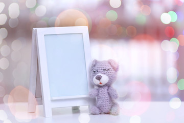 Empty photo frame with toy on table in baby room