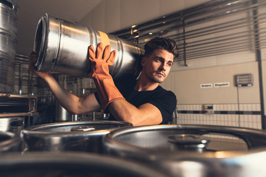 Brewer carrying keg at brewery factory