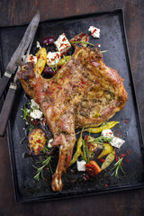 Barbecue Lamb Shoulder with Vegetables and Feta as top view on old metal sheet