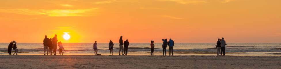 Strandurlaub an der Nordsee, Urlauber genießen den Sonnenuntergang
