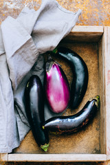 Fresh eggplants in a wooden box, aubergine harvest