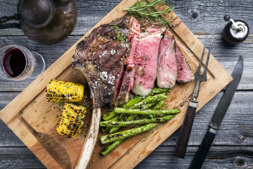 Barbecue Wagyu Tomahawk Steak mit grünen Spargel und Mais  als top view auf Schneidebrett