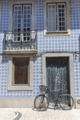 Fototapeta na wymiar Portugal, typical facade with blue azulejos, with a bike 
