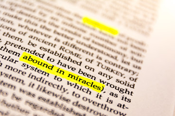 Fototapeta premium Book Highlighted Word Yellow Fluorescent Marker Paper Old Keyword Abound in Miracles