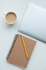 flat lay with laptop computer, notepad with pencil and cup of coffee isolated on white