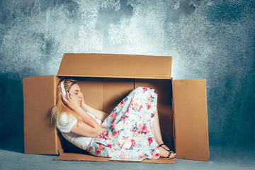 Introvert concept. Woman sitting inside box and working with laptop