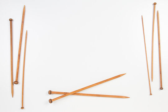 Wooden knitting needles frame with copy space for text on white background