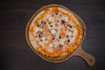 Hot piece of pizza with melted cheese on a rustic wooden table