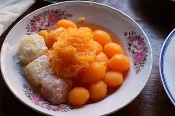 Egg yoke fudge balls cooked in syrup in white plate 