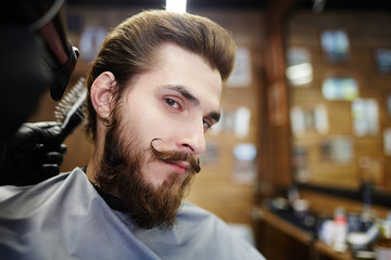 Neat man with beard and moustache looking at camera