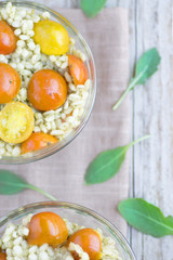 Diet rustic  food: salad with pearl barley and tomatoes  on the background of a white wooden table. Top vies