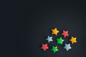 Colorful origami lucky stars on a black background