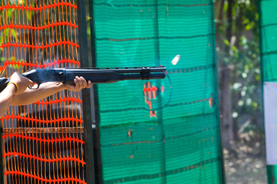 man shooting shotgun at shooting range