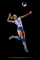 Female professional volleyball player isolated on black