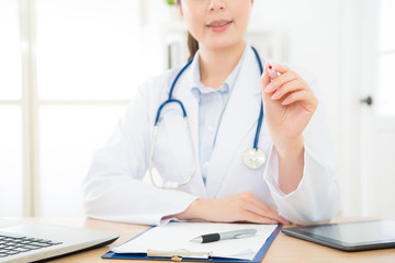 closeup of smiling pretty female doctor using pen