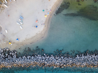 Vista aerea di una spiaggia e di un molo con canoe, barche e ombrelloni. Pizzo Calabro, Calabria, Italia