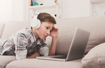 Teenage boy enjoying music in headphones at home