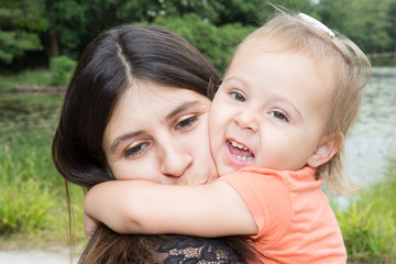 mother and daughter hug in summer park