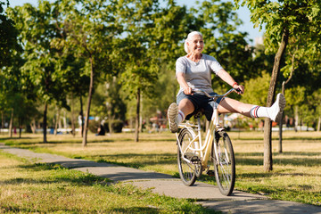 Joyful senior woman riding a bicycle