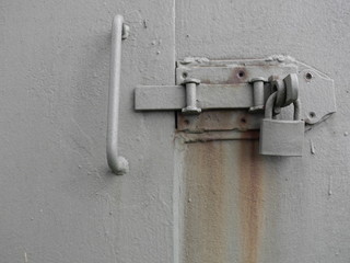 Riegel mit Vorhängeschloss an einer Metalltür