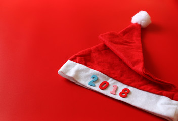 2018 text and Red hat Santa cross on Red background.Copy space,minimal style