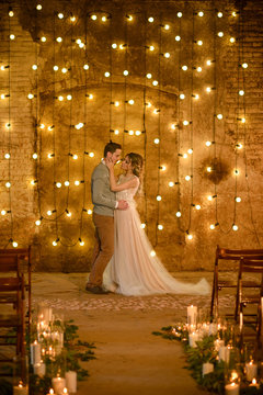 Stylish hipster wedding couple in romantic loft decorations at night