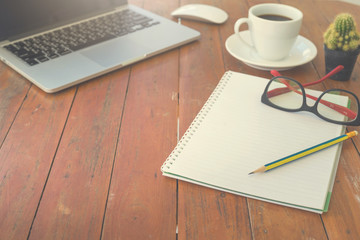 Wooden table with notepad, computer and coffee cup. View from above with copy space.