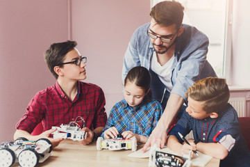 Stem education. Kids creating robots with teacher