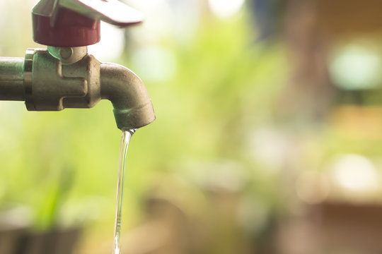 close up water drop from tab, leaking water, save water and water conservation concept