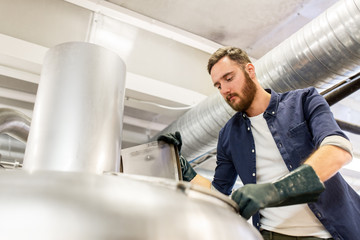 man working at craft brewery or beer plant
