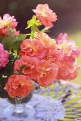 Bouquet of orange roses in a vase in the garden. Orange creeping Rose. Orange Dawn creeping Rose.