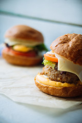 Tasty turkey burgers with corn salad and carrot,mixed seeds served on old board on a rustic wooden table with copyspace.