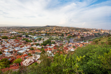 Panorama view of Tbilisi, capital of Georgia country. View from Narikala fortress. Cable road above tiled roofs.