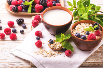 Raspberry, blackberry and blueberry, oatmeal breakfast with milk