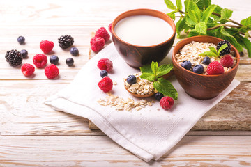 Raspberry, blackberry and blueberry, oatmeal breakfast with milk