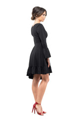 Side view of classy glamour sophisticated woman in black dress looking away. Full body length portrait isolated on white background.