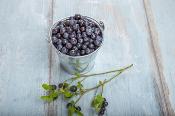 Fresh forest berry, blueberries in a glass plate on a wooden table