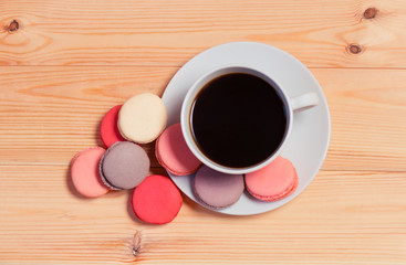 Obraz premium Cup of coffee with macaroons on wooden background