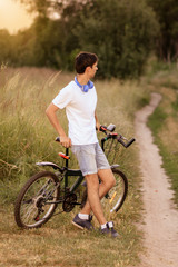 Naklejka premium Attractive young guy with road bicycle outdoors