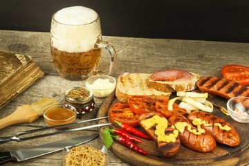 Grilled sausage with mustard on a wooden cutting board. Summer barbecue party. Fat meal.