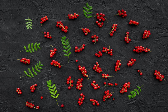Berry pattern. Red currant and leaves on black table background top view