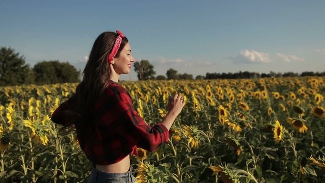 Carefree woman running through field of sunflowers