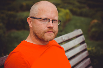 Portrait of mature simple hipster man, with red beard walk at the European city and thinking about something