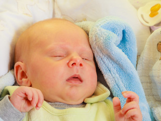 Little newborn baby sleeping calmly in blanket