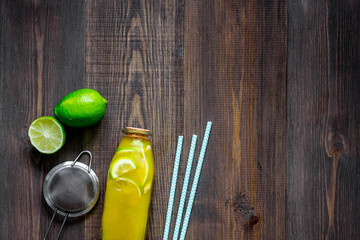 Making lemonade. Cookware, fruits, bottle of lemonade on wooden table background top view copyspace