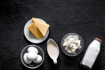 Natural food. Milk, cottage, cheese, eggs on black stone background top view copyspace